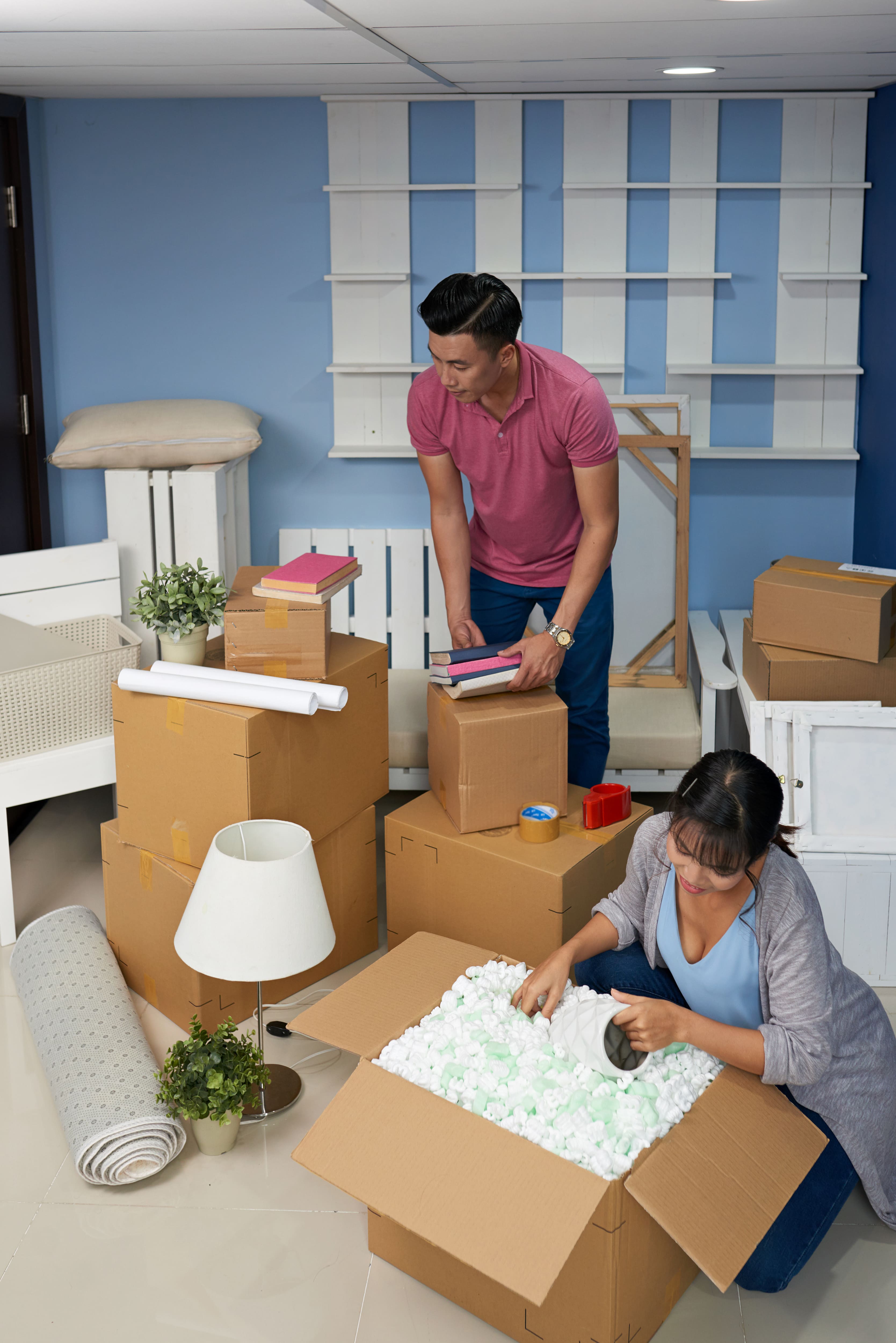 Couple unpacking boxes in their new home, enjoying the process of settling in